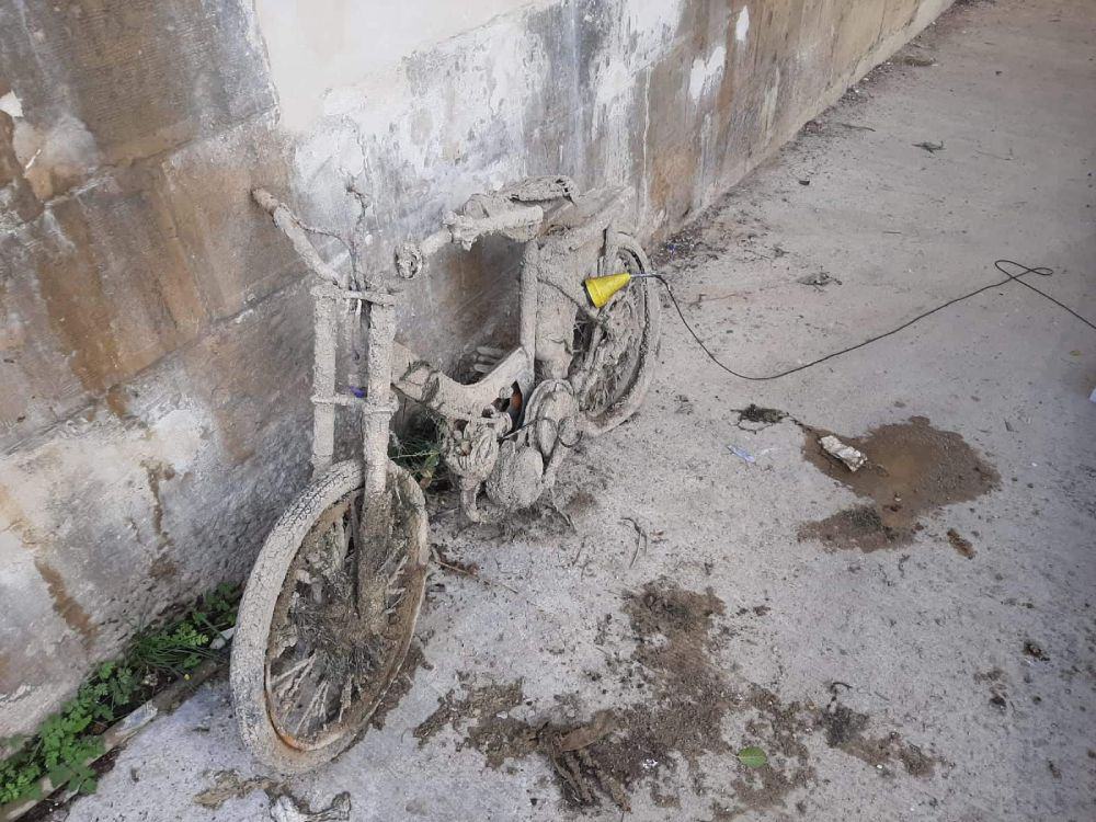 Starý moped opřený o betonovou zeď