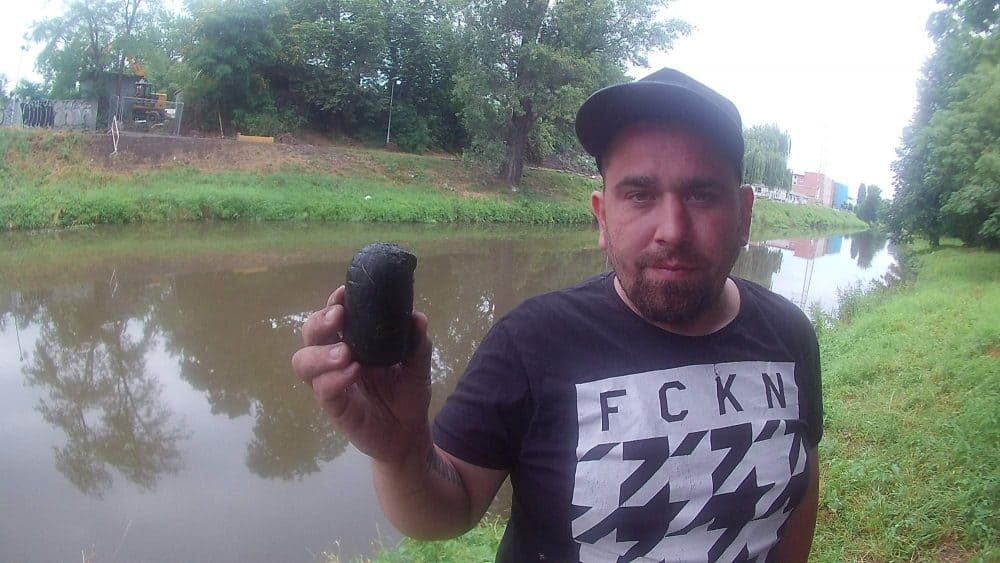 lovec Majkl drží v ruce granát